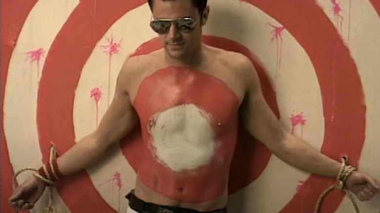 Johnny Knoxville tied to a target for a paintball stunt