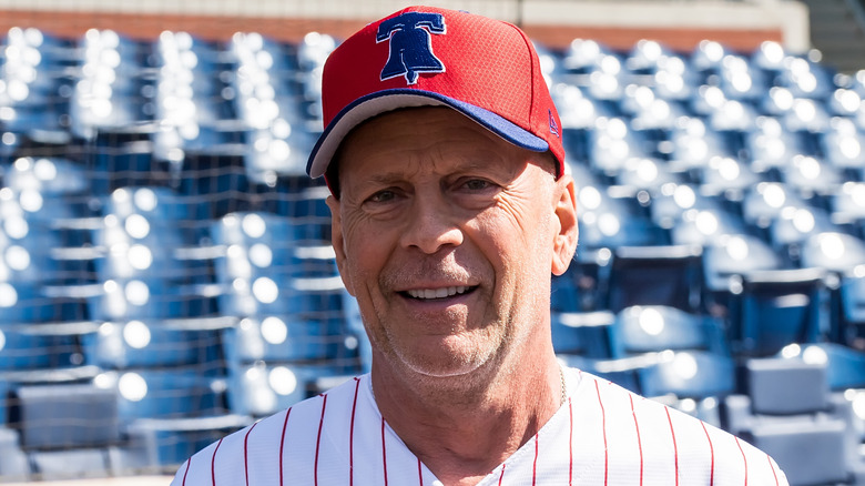 Bruce Willis smiling in a baseball cap