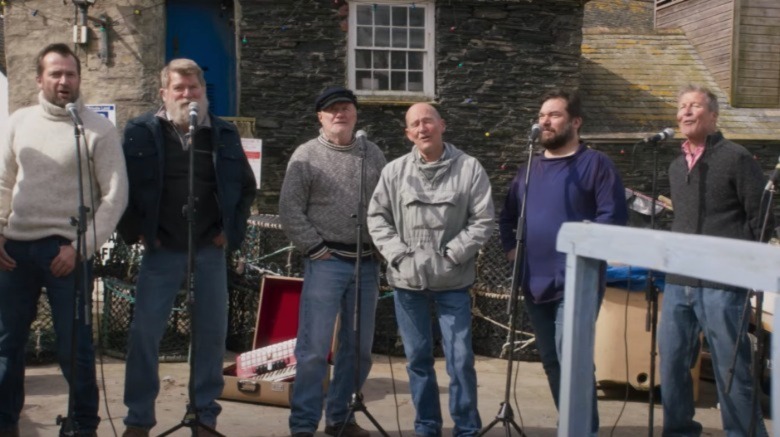 Cast of Fisherman's Friends singing microphones