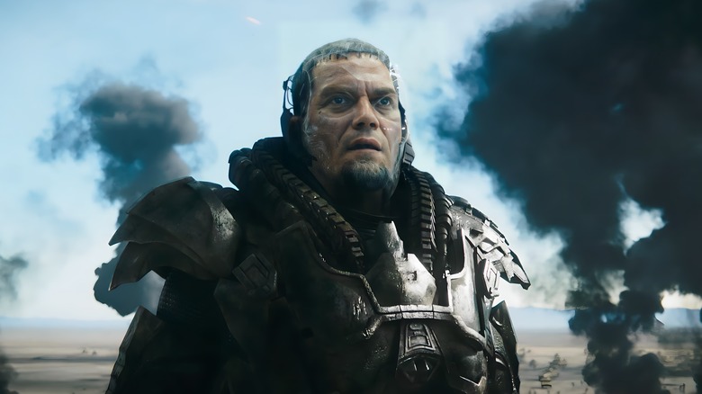 General Zod stares at something off screen in front of smoke clouds