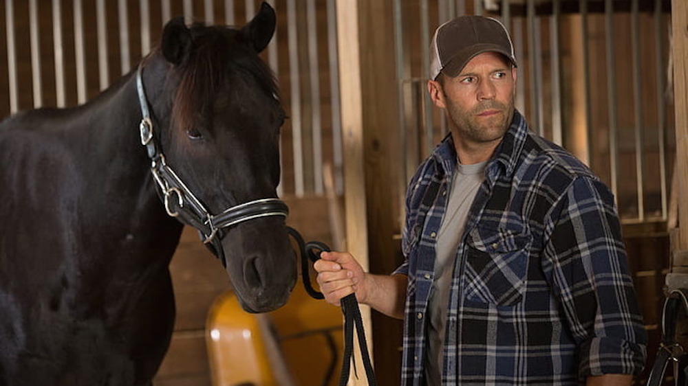 Jason Statham holding horse's reins