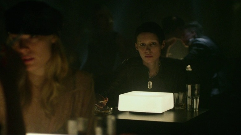 Lisbeth sitting in dark bar