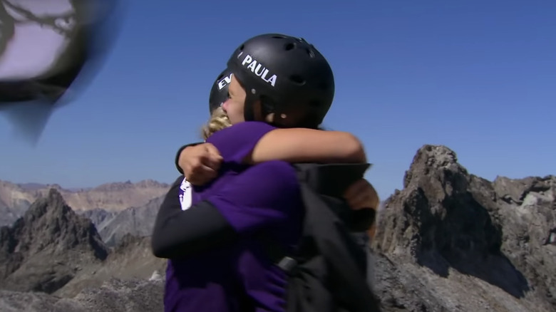 The girls hug on the mountain top