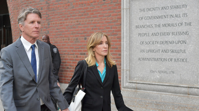 Felicity Huffman and her lawyer walk outside a courthouse