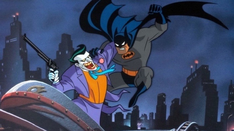 Batman jumping on Joker, who's holding a large pistol