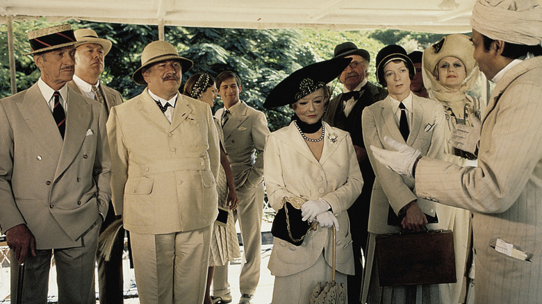 Poirot standing with cruise guests