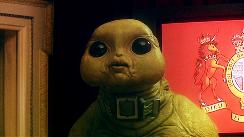 Slitheen in front of flag