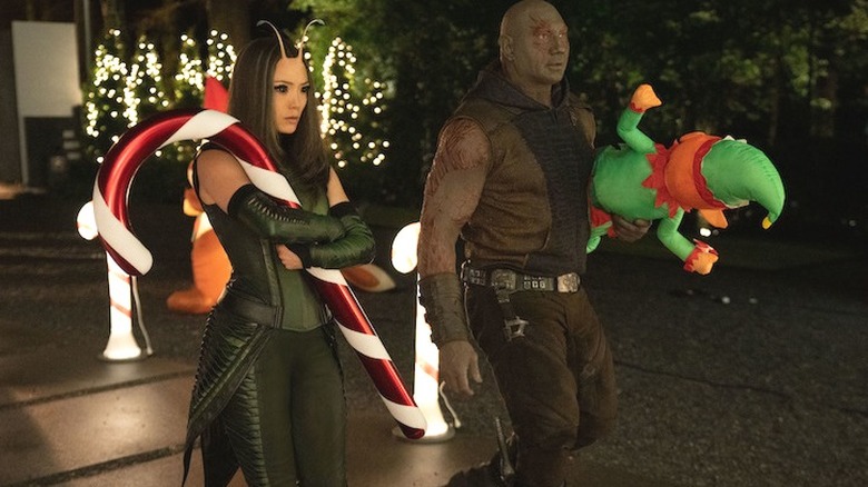 Mantis and Drax holding holiday decorations outside