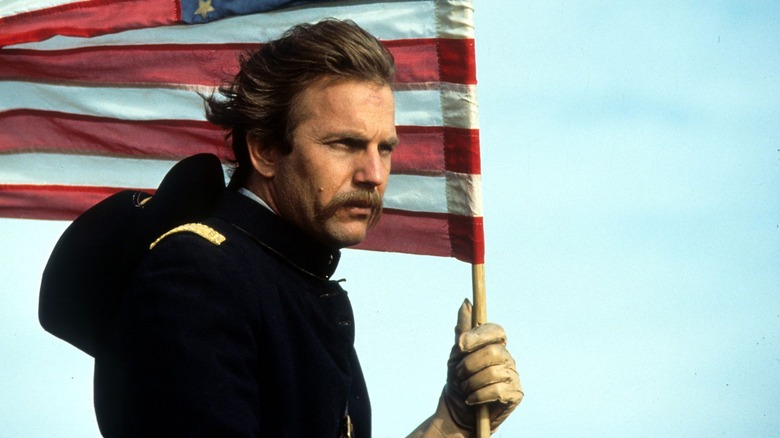 John Dunbar holding an American flag