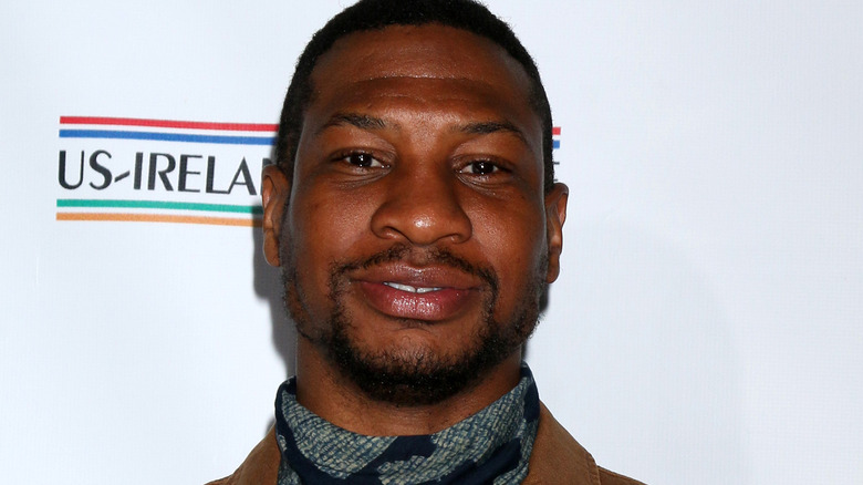 Jonathan Majors smiling into camera