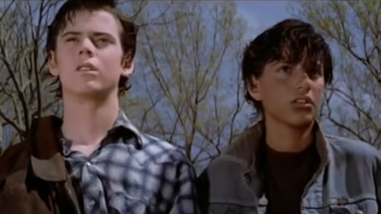 Ponyboy and Johnny looking on