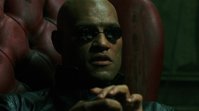 Morpheus sits in red armchair