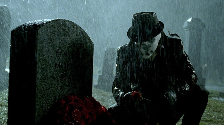 Rorschach putting roses on a grave