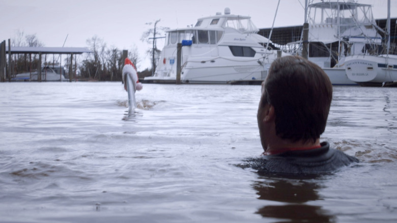 Santa Jaws swimming toward a man