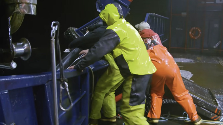 The Saga's crew holding onto the life raft as it's pulled into the sea