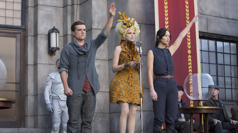 Peeta and Katniss giving salute on stage