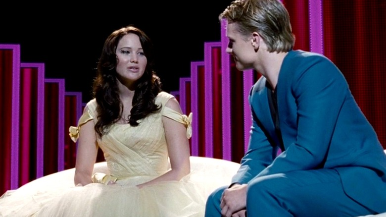 Katniss and Peeta on a talk show being interviewed by Flickerman