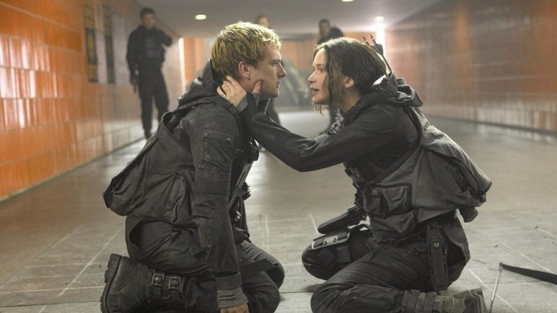 Katniss and Peeta kneeling in tunnel