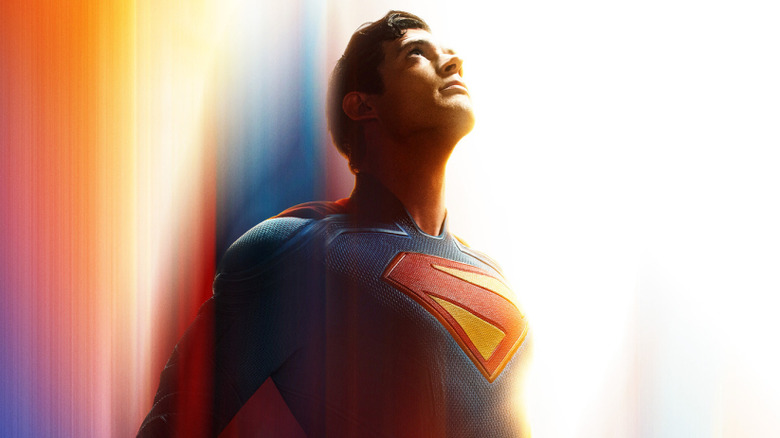 David Corenswet as Superman (2025) flying against a rainbow background