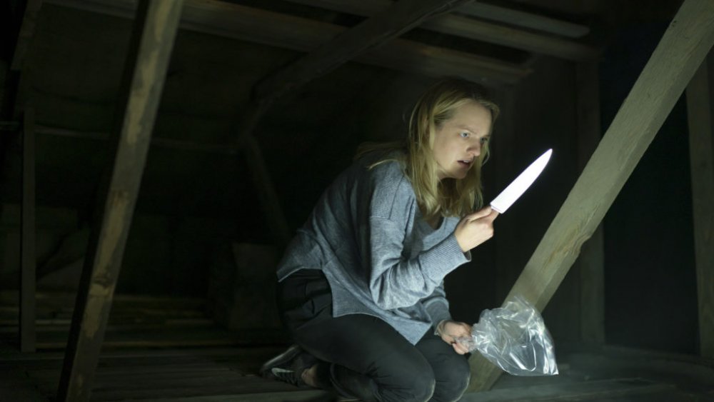 Cecilia Kass holding knife in attic