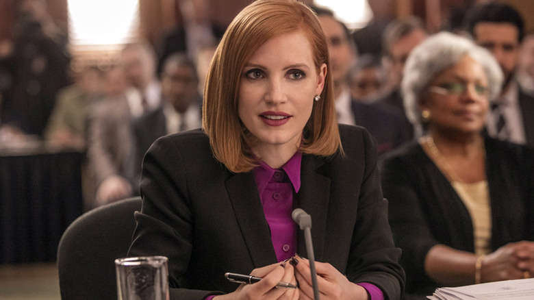 Miss Sloane in front of microphone