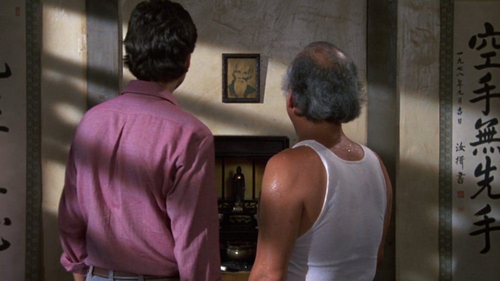 Daniel LaRusso and Mr. Miyagi look at a portrait of Miyagi Shimpo Sensei in The Karate Kid Part II