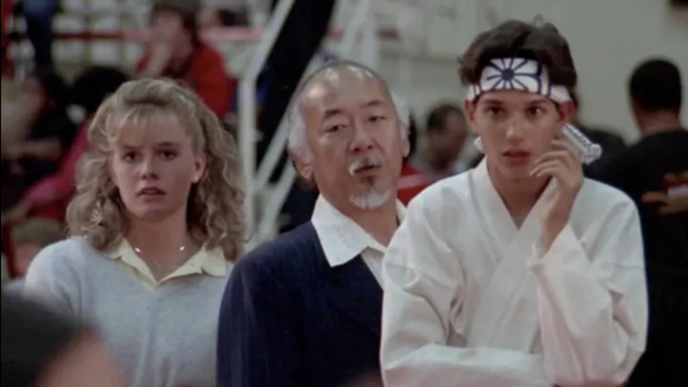 Ralph Macchio as Daniel LaRusso, Elisabeth Shue as Ali Mills, and Pat Morita as Mr. Miyagi in The Karate Kid