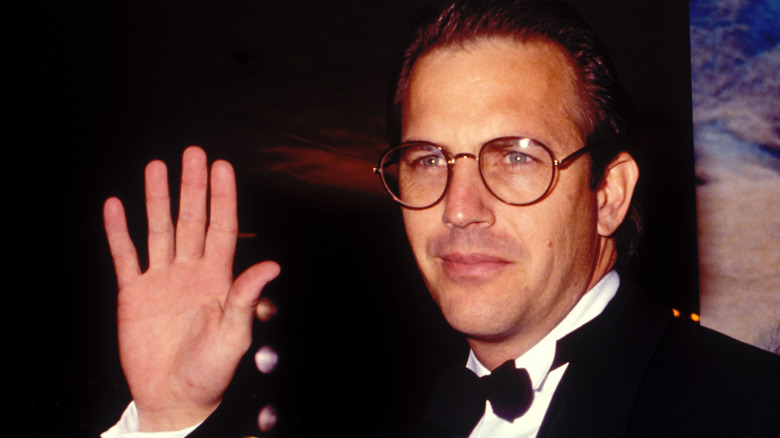 Kevin Costner waving glasses