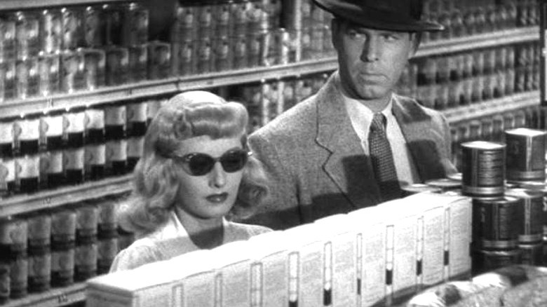 MacMurray and Stanwyck look serious in aisle