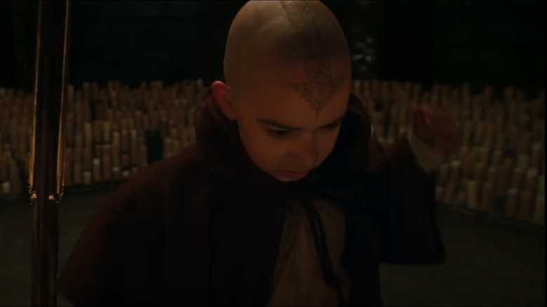 Aang holding staff and surrounded by candles