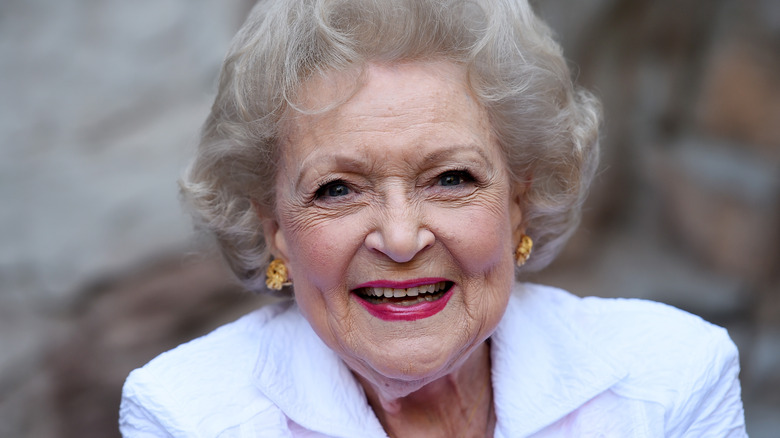 Betty White smiling in white coat