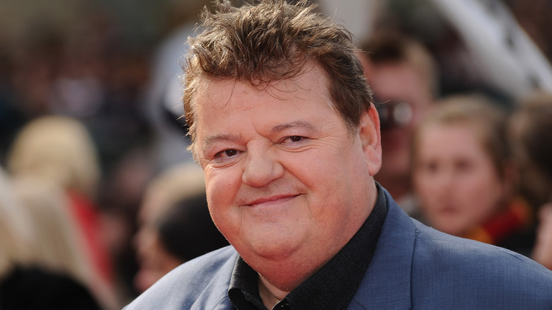 Robbie Coltrane smiling wearing blue coat