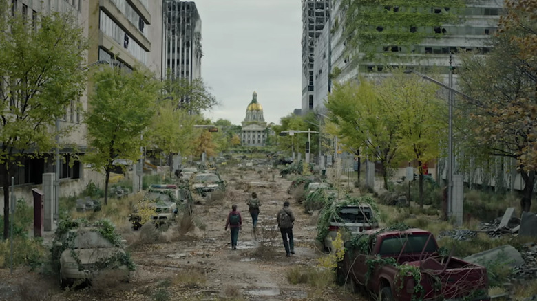 a group of survivors walking through a post-apocalyptic city