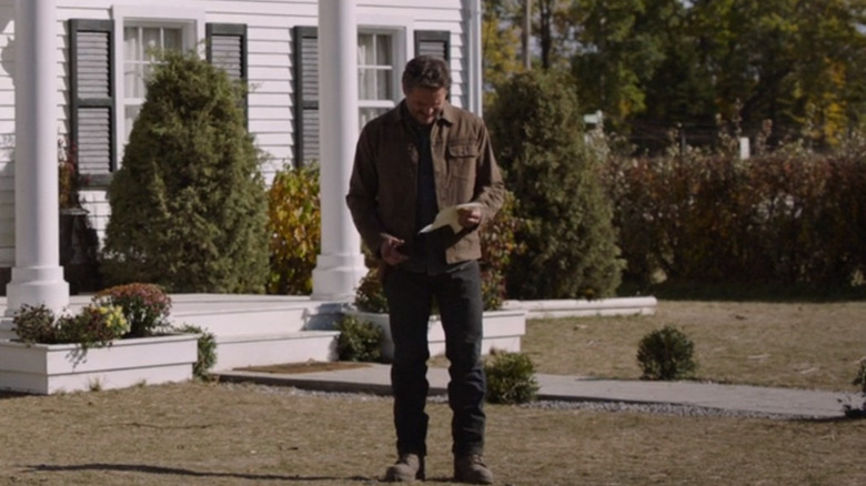 Joel reading Bill's letter outside his house