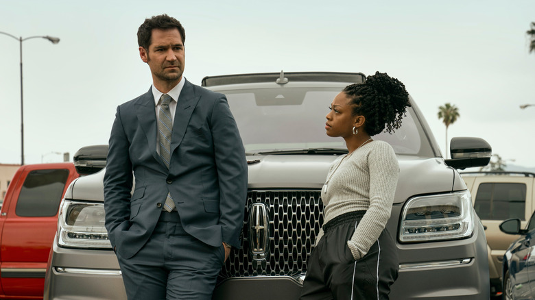 Haller and Freeman stand in front of a Lincoln Navigator in "The Lincoln Lawyer" (2022-present)