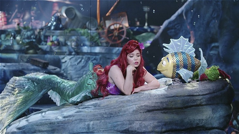 Live action Ariel lounging on a rock