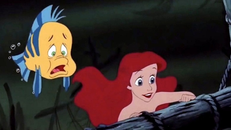 Flounder and Ariel look on at the ship's wreckage in The Little Mermaid (1989)