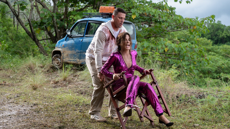 Channing Tatum and Sandra Bullock working with a chair in "The Lost City"