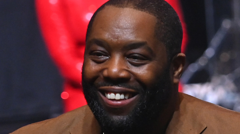 Killer Mike smiles in brown suit