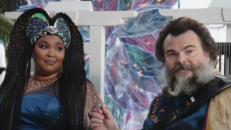 Lizzo looks at Jack Black with colorful background