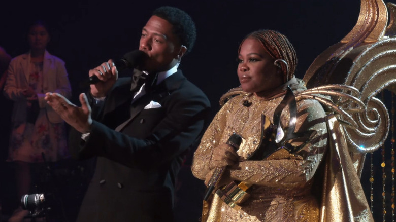 Amber Riley stands next to Nick Cannon and wins The Masked Singer