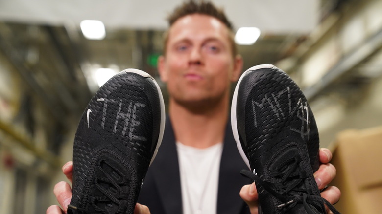 Miz holding up signed shoes