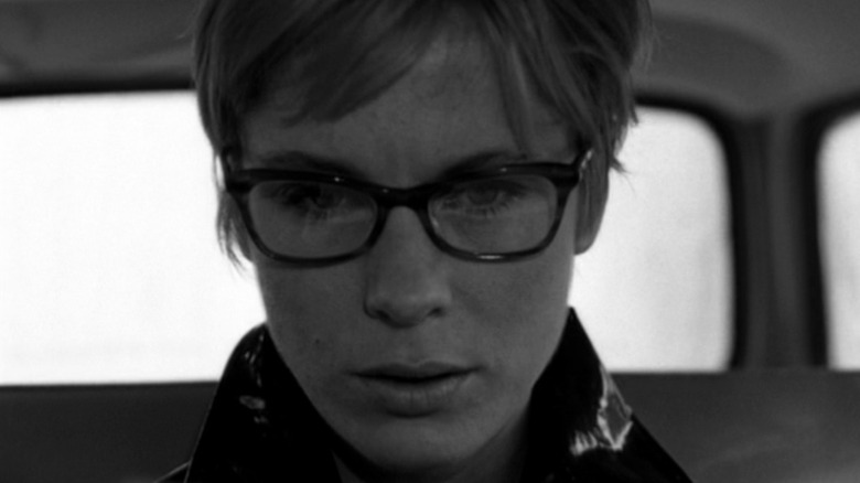 Bibi Andersson looks down in car