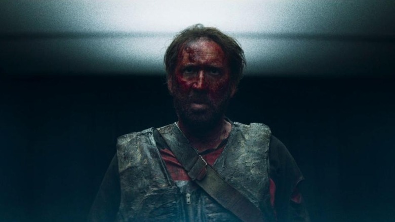 Nicolas Cage, covered in blood, staring ahead