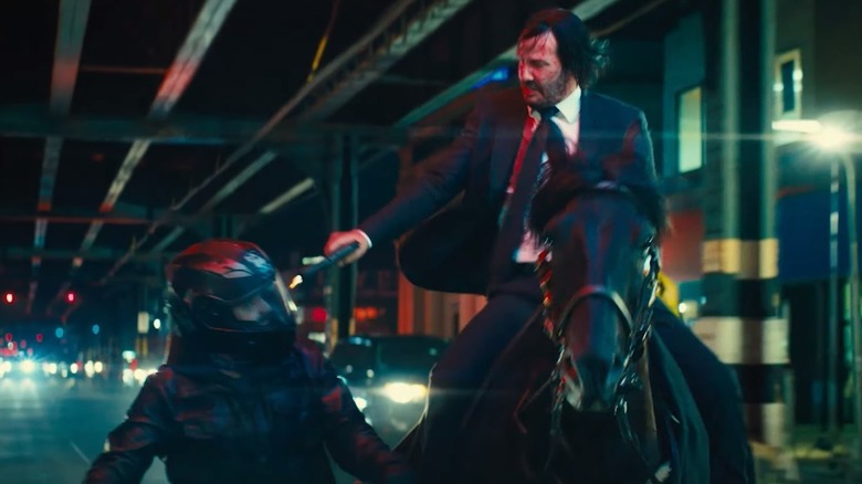 John Wick on horseback shooting a motorcycle gangster