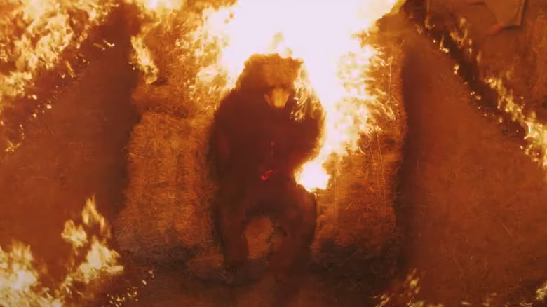 Burning bear suit on hay bales