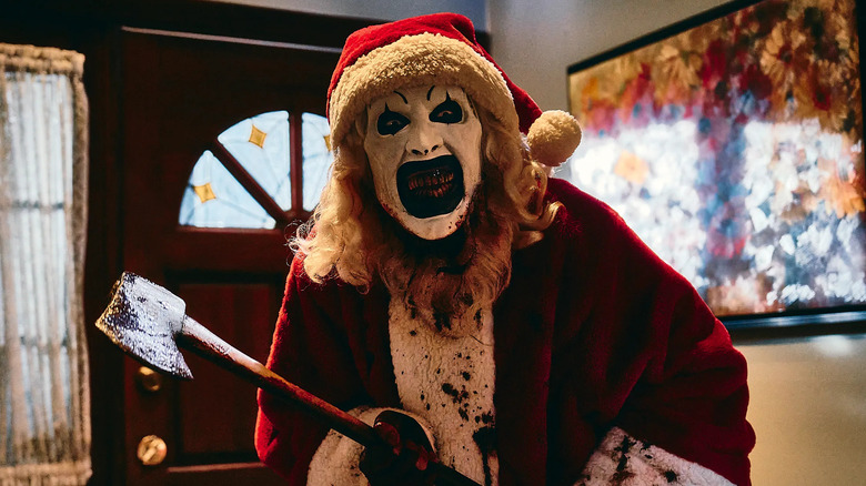 Art the Clown dressed like Santa Clause and wielding an ax