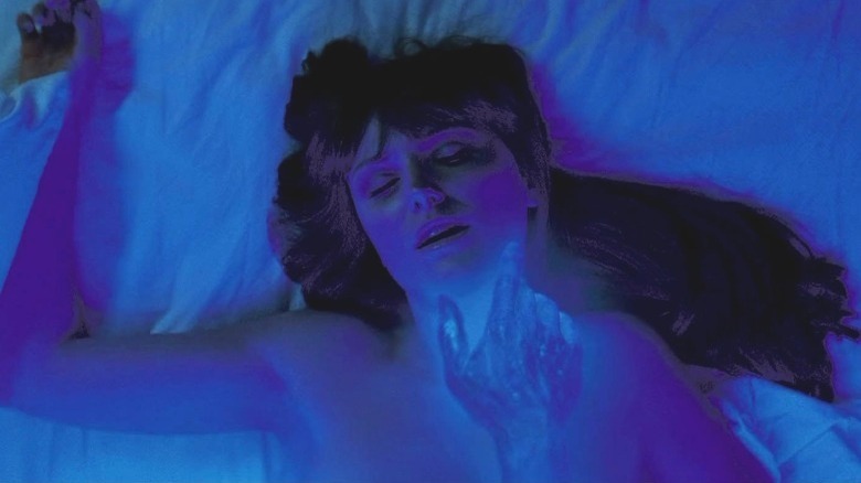 Laurie in bed touched by blue hand