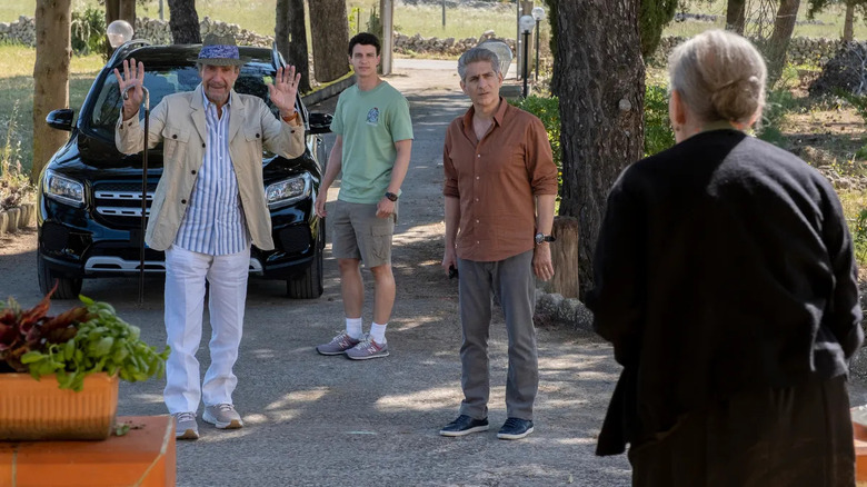 3 men stand in driveway in front of an old woman's house