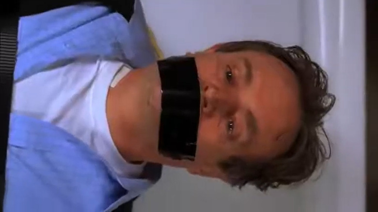 Dr. Donald "Ducky" Mallard lying down with tape over his mouth